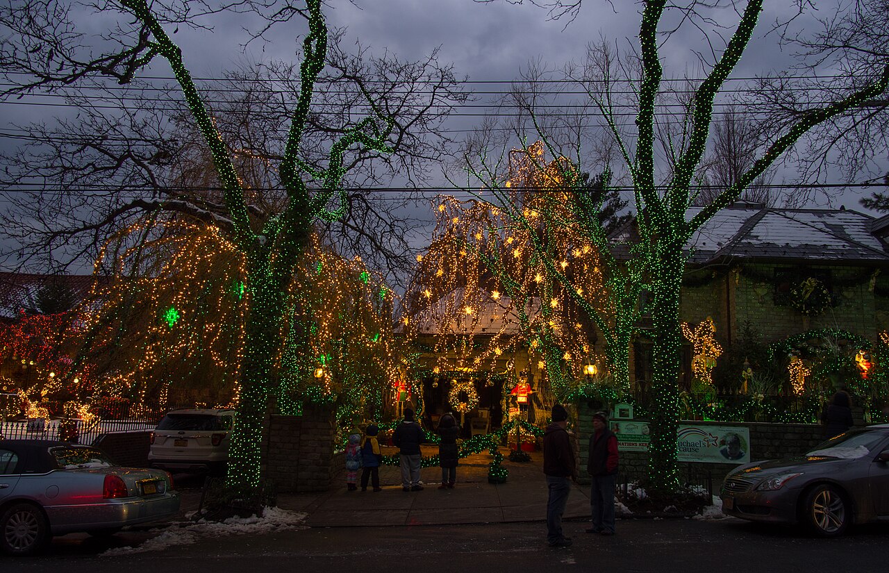 A Dyker Heights house and trees wrapped in lights