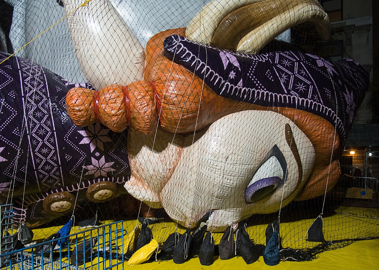 A giant character balloon being inflated under nets the day before the Macy’s parade