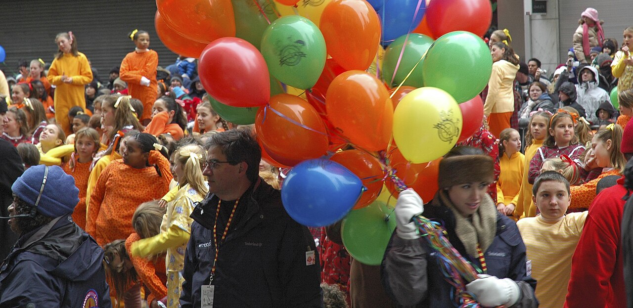 Marchers in costume carrying bunches of balloons in the Macy’s parade